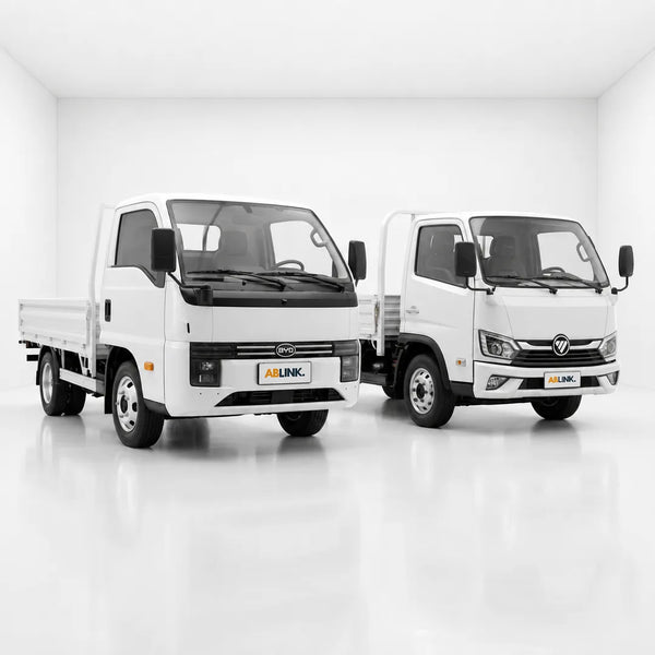White BYD T35 and Foton eMiler trucks in a studio, electric 10ft lorry Singapore comparison